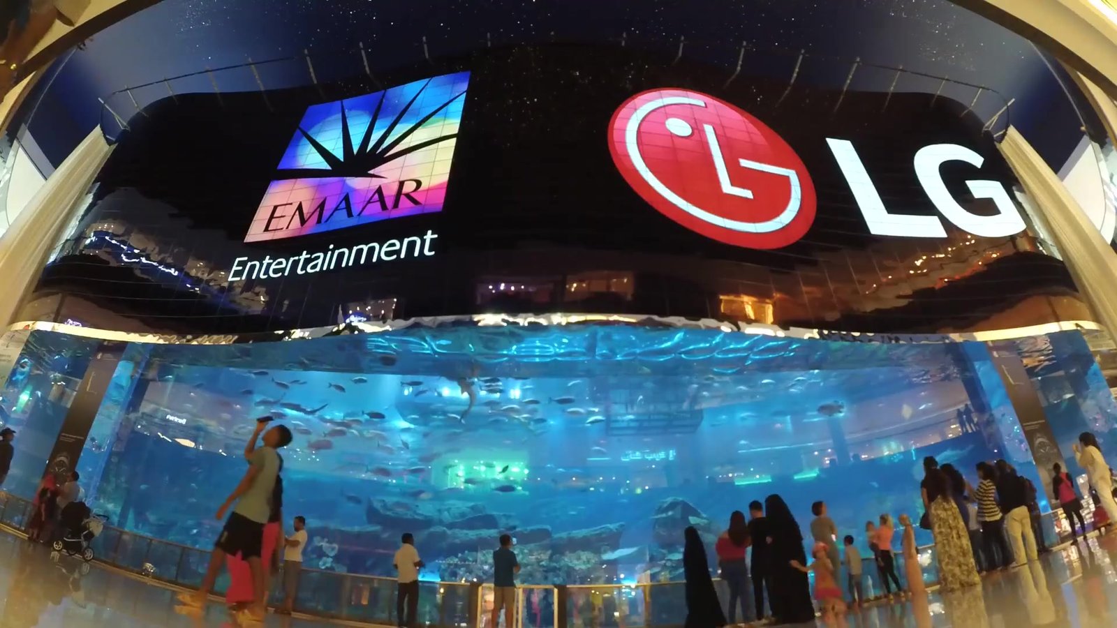 Curved OLED video wall above Dubai Aquarium in Dubai Mall, with Emaar Entertainment and LG on screen and the tank below.